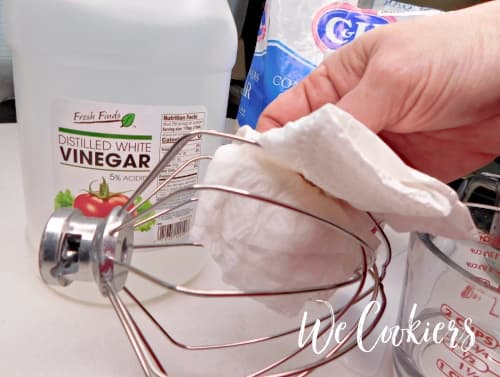 Photo showing to wipe off whisk attachment with vinegar before making royal icing Step 2. Wipe down all utensils with vinegar