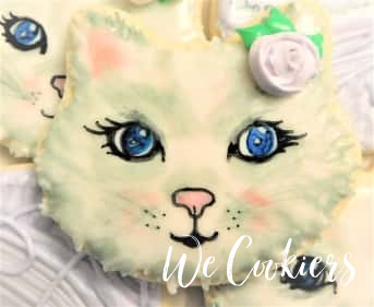 Decorated cookie of a kitty face Kitty cookie. Decorated by water coloring with food gels.