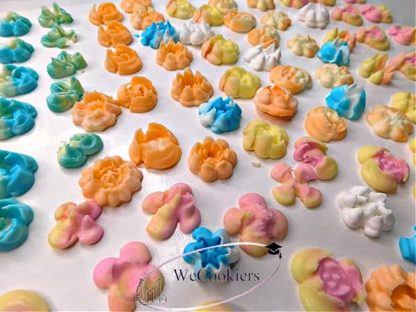The image shows mini flowers made of royal icing and piped using the Nifty Nozzles, mini Russian piping tips.