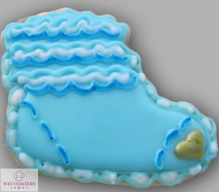 There is no argument that baby cookies decorated with royal icing are some of the cutest sugar cookies! See more ideas, techniques, RI transfer templates, and more here: This image is of a baby boy's bootie cookie with blue royal icing and decorative piping. A food color marker is used for the heel and toe stitches.