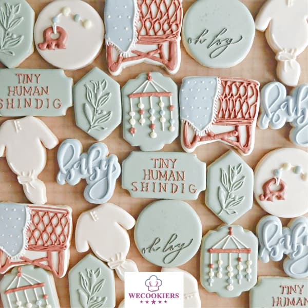 Boy baby shower cookies with a boho flair. This darling set is in the theme of 'Tiny Human Shindig'. Get more inspo, techniques, and ideas: Baby boy shower cookies. This image shows the theme 'Tiny Human Shindig' with boho flair.