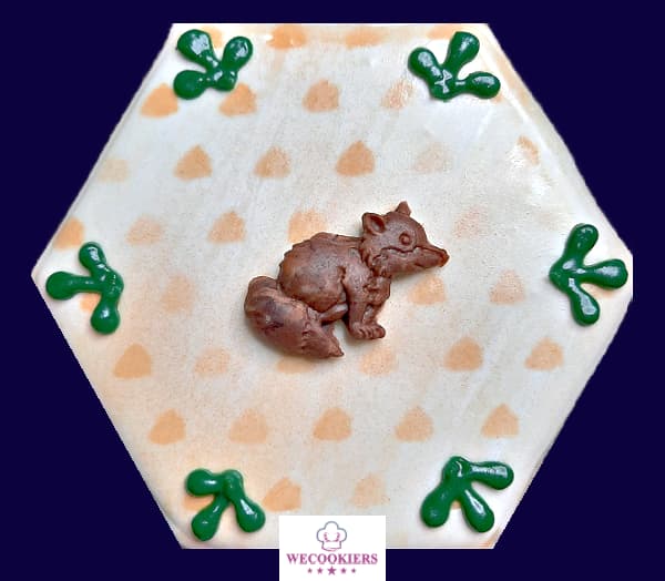 There are so many mediums to place on cookies. Here, I used a fondant from a silicone mold for a nice 3D effect. Learn all about cookie-ing: A fondant raccoon on a cookie for a woodland baby boy shower theme.