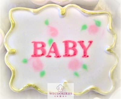 This darling cookie shows the wet-on-wet technique with roses in the background in white flood icing. It is bordered with gold and the name is written with a food color marker. Use any cutter for a baby name for baby girl shower cookies. The background is wet-on-wet with roses. The name was written with a food color marker. More techniques, cutters, & RI transfer sheets: