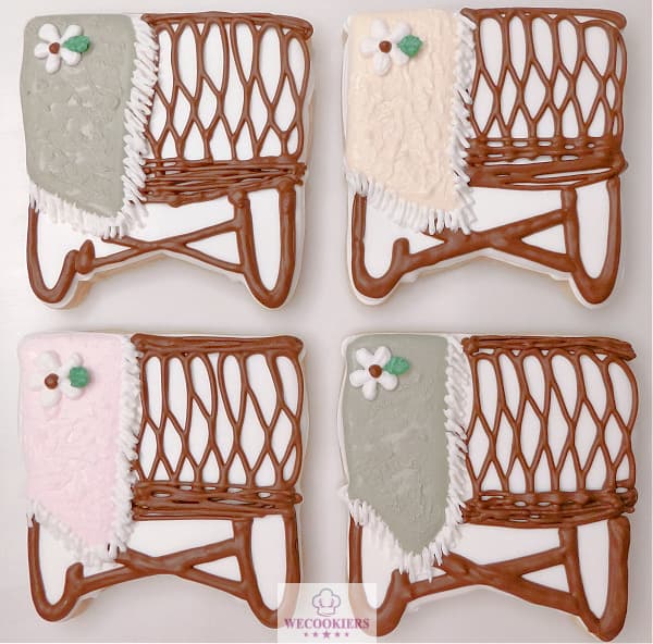 This image shows 4 ways to decorate the popular boho wicker bassinette cookie cutter. It shows a baby blanket hanging over the sides in various colors with daisies piped on the blankets. The beautiful boho wicker bassinet. Perfect & easy for baby girl shower cookies. Customers are crazy over these! More ideas, techniques, popular cutters, & baby RI transfer sheets: