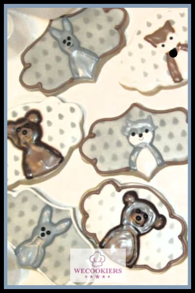 If you do not have a woodland-themed cookie cutter set, you can easily pipe them on. I stenciled the background with an airbrush, but you could use dots with the wet-on-wet technique. Piped woodland animals for a baby boy shower theme. I stenciled on the background with an airbrush.