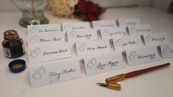 As a calligrapher, I enjoy using my PICO + projector to aid me without drawing and erasing lines. Image showing calligraphy place cards written with the help of the PICO + projector to project the lines to keep the writing straight and properly slanted.