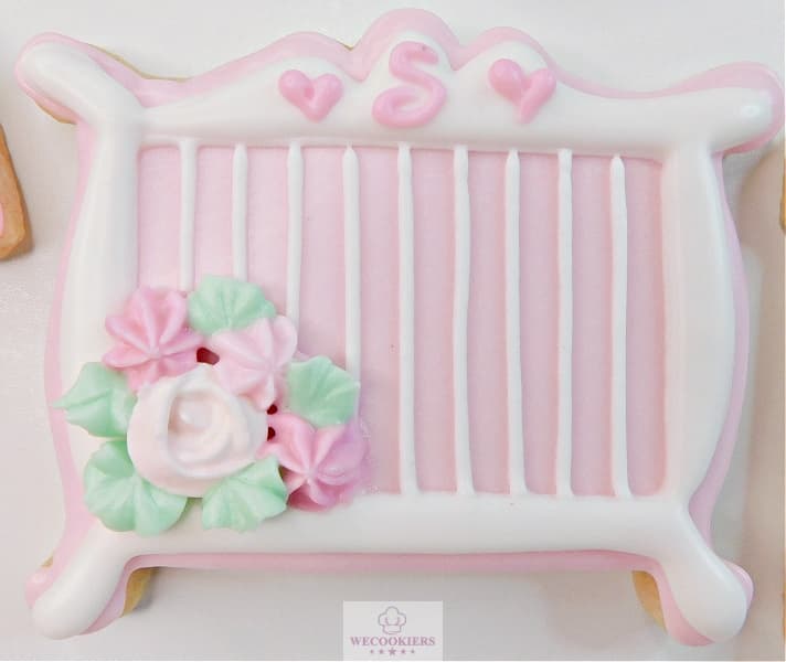 One of my favorite baby cookies! This cutter is a great addition to your baby cutters. It is so simple to decorate. See more ideas, baby RI templates, popular cutters, and more! This image shows a decorated baby crib cookie for a girl with white and pink royal icing. I piped a little blanket over the side.