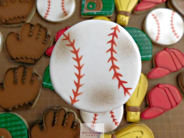 Airbrushing sports sugar cookies, like this baseball theme, will give it a real and natural look. See this affordable airbrush!https://www.wecookiers.com/sports-sugar-cookies.html Baseball themed cookies