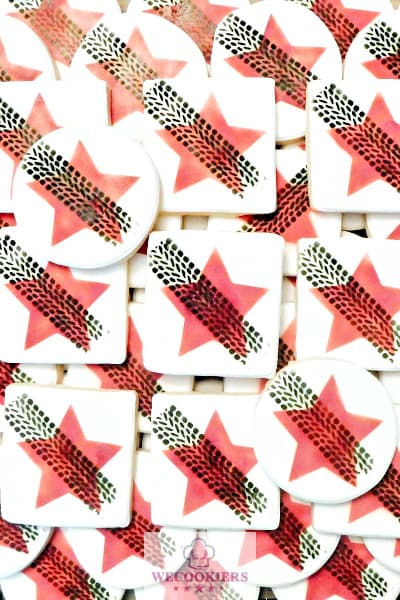 Cookie stenciling techniques using an airbrush to make the red star and black tire tracks on top of the star for a car dealership open house.