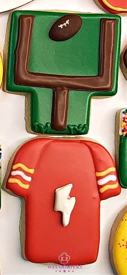 Using royal icing transfers for footballs, baseballs, basketballs, etc., will make short work of decorating sports sugar cookies! See more here:https://www.wecookiers.com/sports-sugar-cookies.html Football cookies with royal icing transfers in the shapes of footballs and lightning