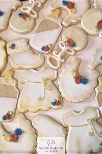 This baby shower cookie set was simply white with gold airbrushing on royal icing. I added cream, blue, and dark pink flourishes.