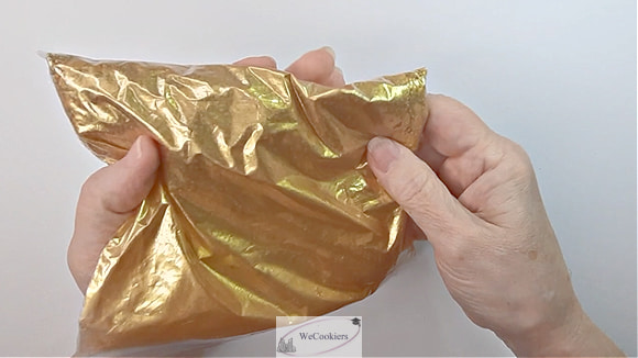 The photo shows a bag of beautiful gold sprinkles being transitioned from their original color.