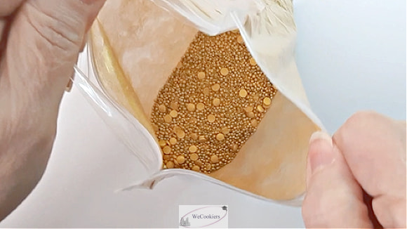 This photo shows an open bag of gold sprinkles that were originally another color.