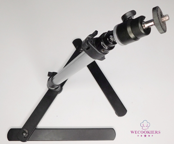 This mini projector mount shows a side view, along with the rod that can be extended. The legs will fold in and out. This also shows how the projector is attached. This is the side view of the assembled tabletop projector mount